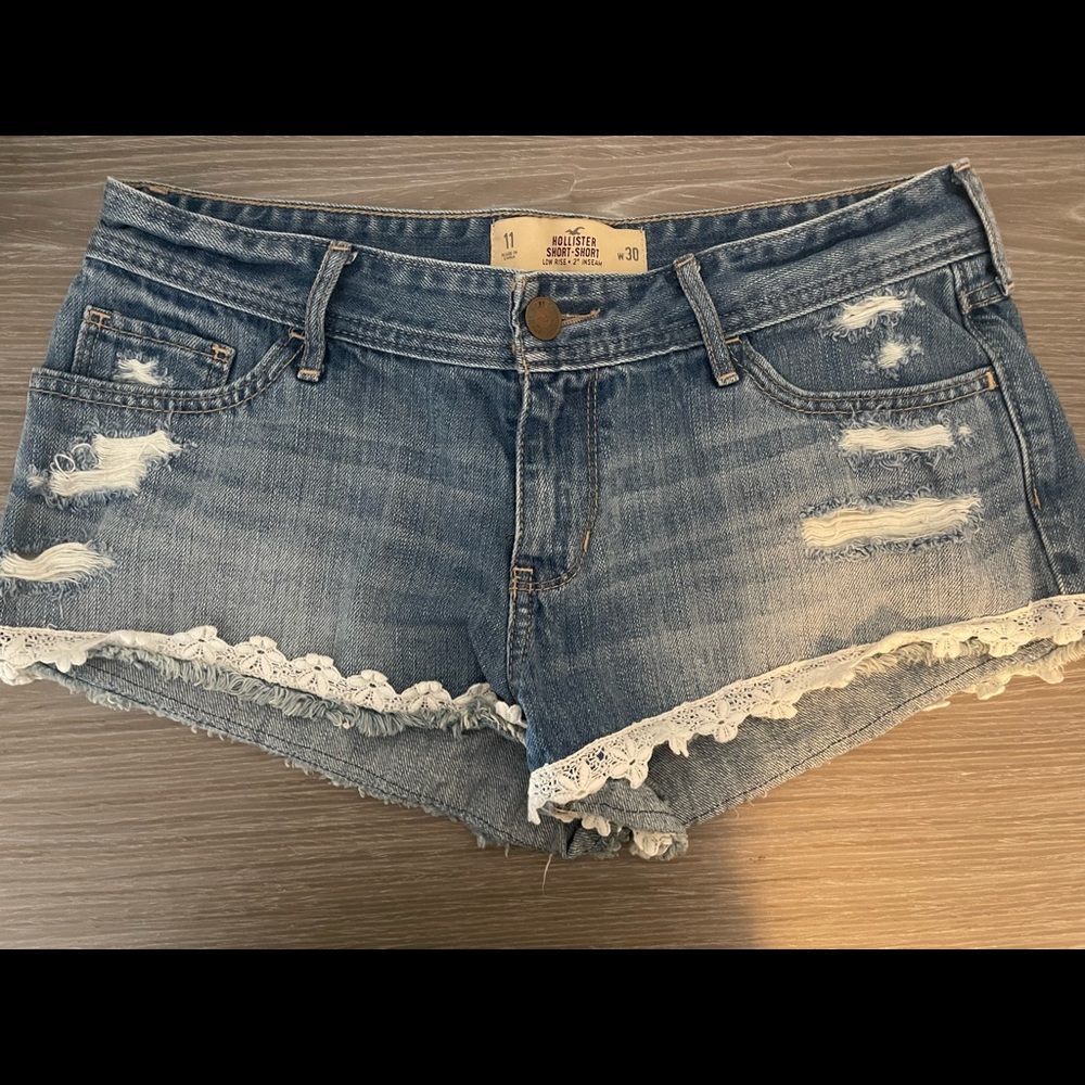 Hollister “Daisy Duke” Jean shorts with white lace trim. Size 30.